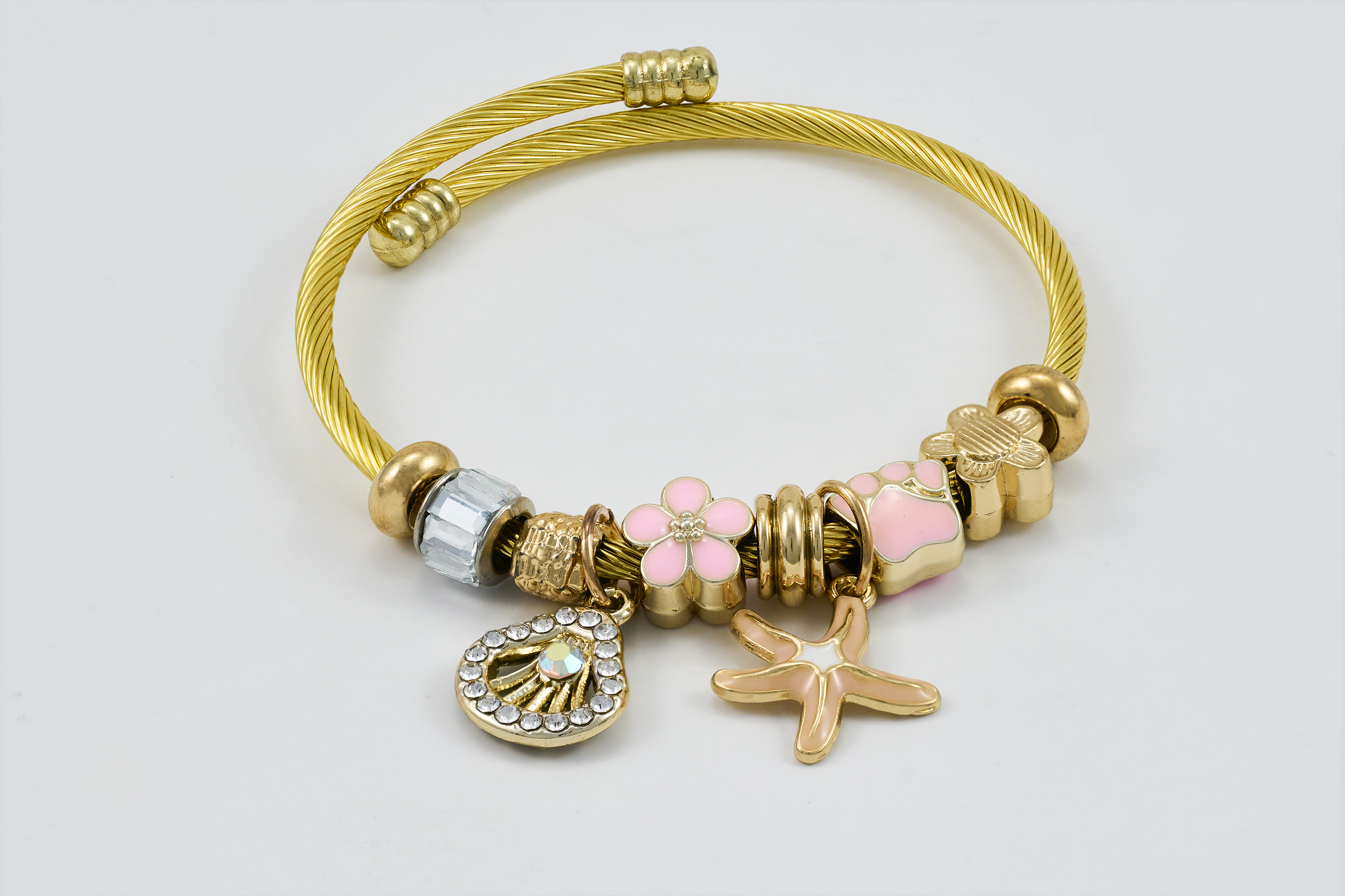 Gouden armband met roze kralen en elegante bedels