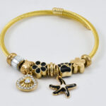 Gouden bangle met bedels en kristallen accenten