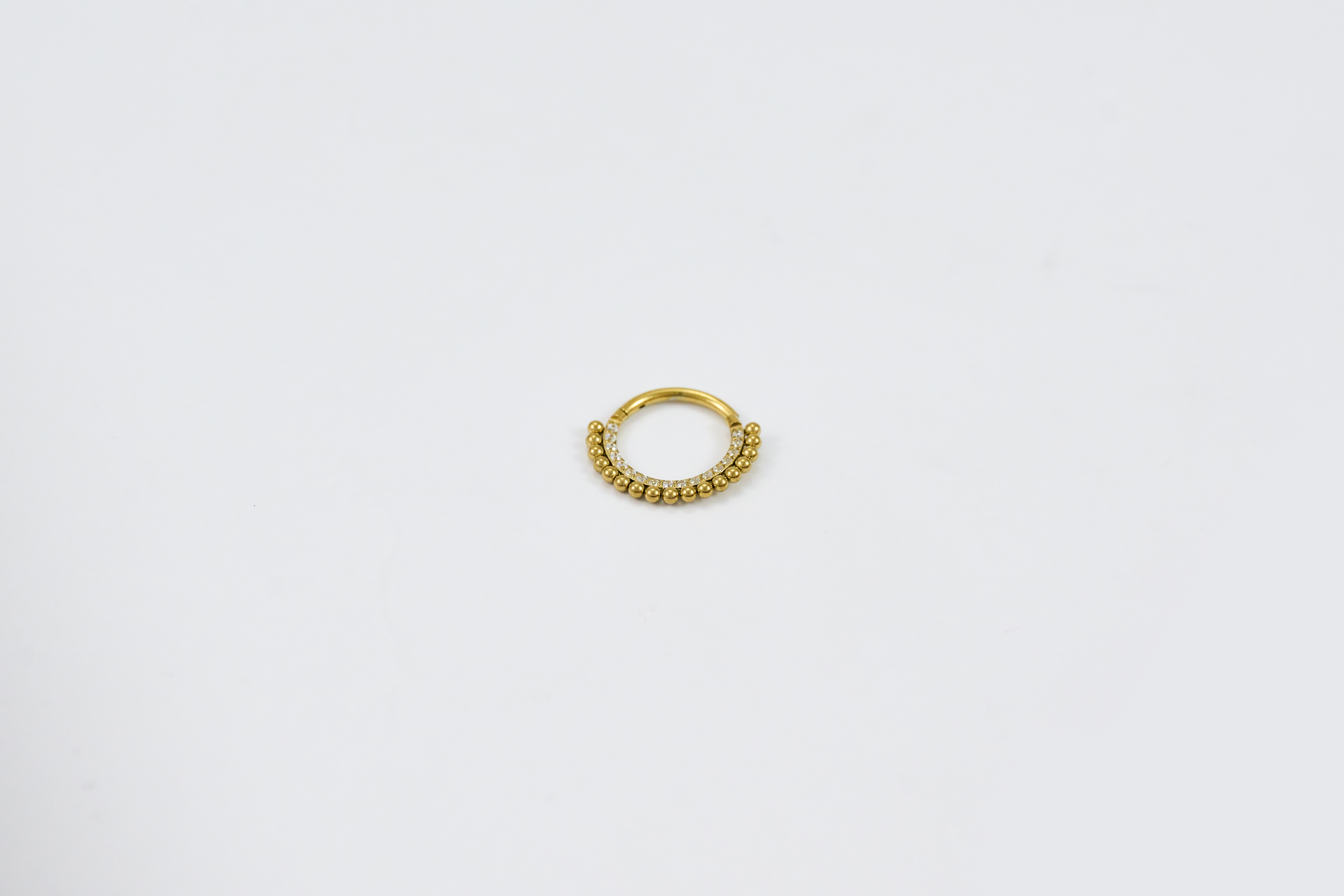 Gouden ringpiercing met subtiel patroon