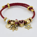Rode koordarmband met gouden bedels en verfijnde afwerking